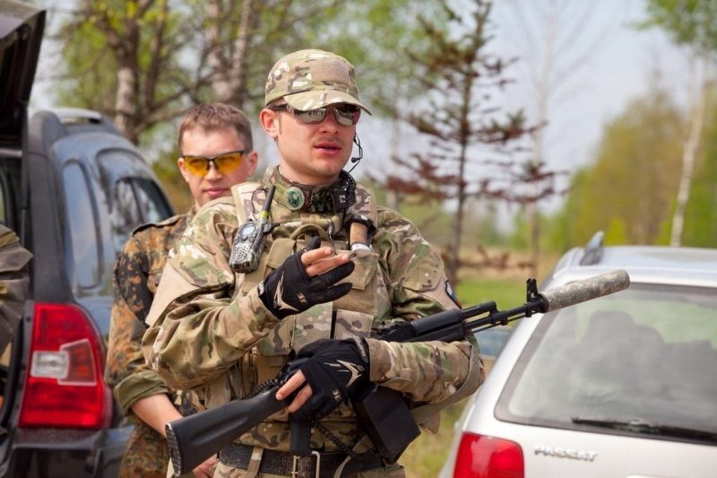 Боец LASERWAR в камуфляже с рацией готовится к бою.