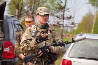 Боец LASERWAR в камуфляже с рацией готовится к бою.
