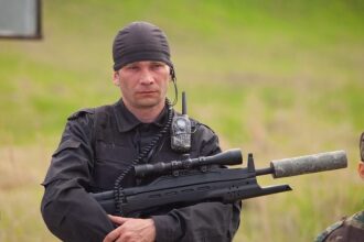 Боец LASERWAR с винтовкой и рацией готовится к бою.