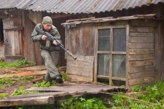 Боец LASERWAR в движении, прицеливается из-за укрытия.