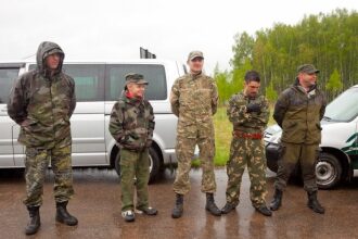Пятеро бойцов LASERWAR в камуфляже у серебристого минивэна.