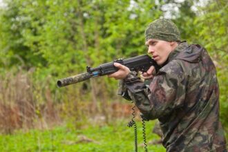 LASERWAR: боец с оружием в камуфляже на природе