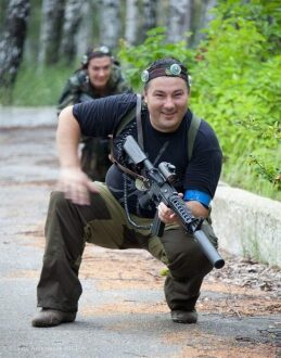 Лазертаг-схватка: игрок в приседе с оружием LASERWAR