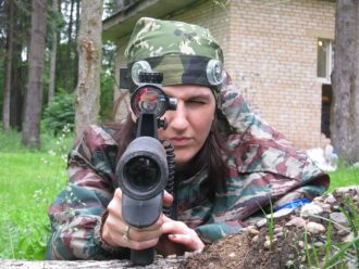 Девушка-боец LASERWAR прицеливается через оптический прицел.