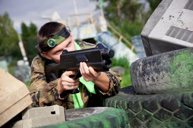 Боец LASERWAR в маскировке ведет прицельный огонь.