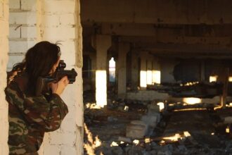 LASERWAR: девушка целится из-за бетонной колонны