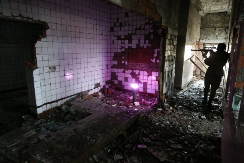 Боец LASERWAR прицеливается в разрушенном здании