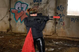 Девушка с лазертаг-винтовкой LASERWAR в заброшенном здании