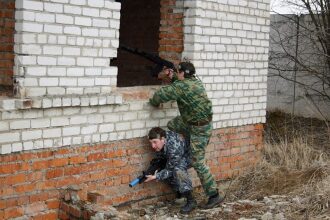 Лазертаг-бойцы LASERWAR занимают позиции у кирпичной стены
