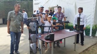 Дети пробуют лазертаг-оружие LASERWAR на стенде.