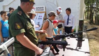 Маленький стрелок изучает оптику лазертаг-винтовки