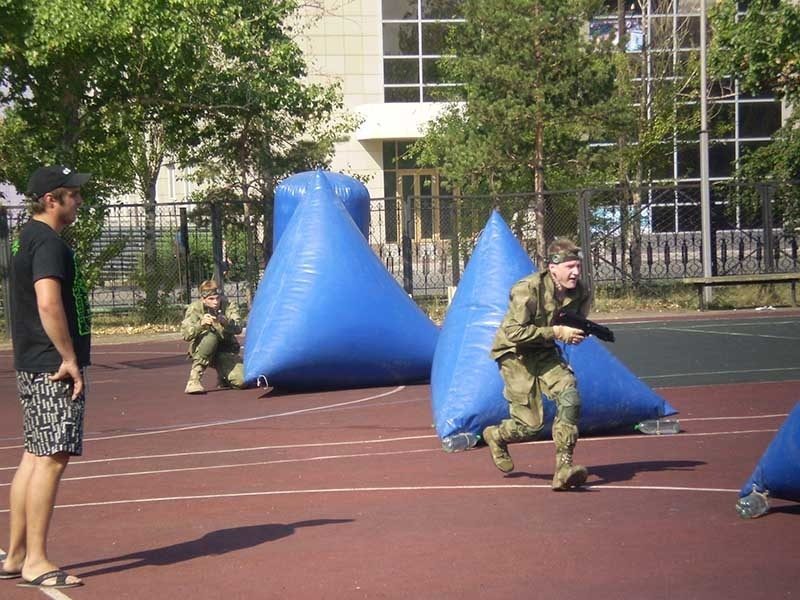 Игроки LASERWAR в камуфляже на арене с надувными укрытиями.