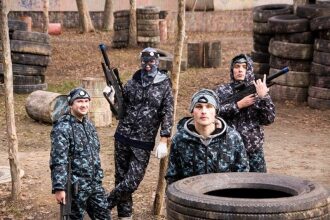 Бойцы LASERWAR в камуфляже укрываются за шинами.