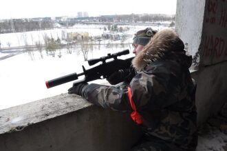 Лазертаг-игрок в зимнем камуфляже с оптическим прицелом