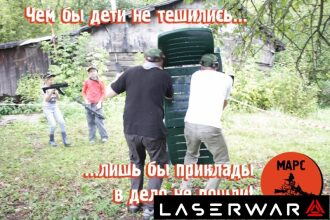 Дети и взрослые играют в лазертаг на природе.